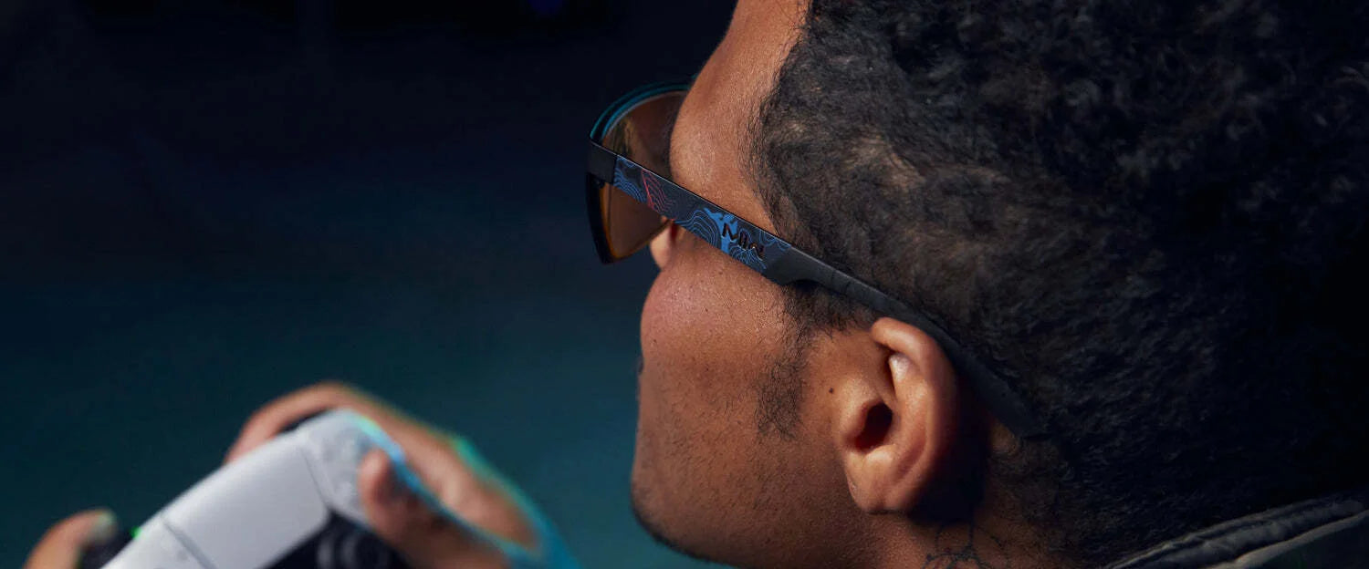 Intensely focused on a screen, a gamer grips a controller while wearing Gunnar Call of Duty Covert Edition Computer Glasses with patented lens technology. Intensely focused on a screen, a gamer grips a controller while wearing Gunnar Call of Duty Covert Edition Computer Glasses with patented lens technology.