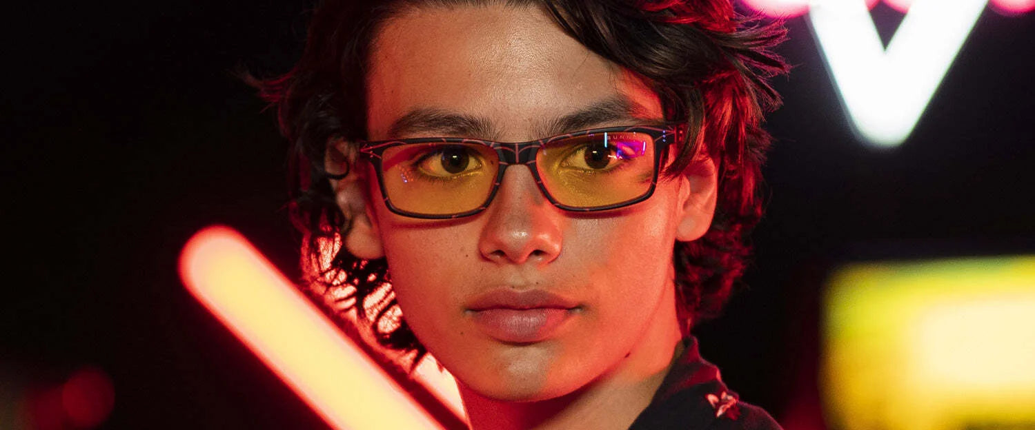 Wearing Gunnar Cruz Spider-Man Miles Morales Edition Computer Glasses, a person looks sideways with neon lights glowing behind. The sturdy nylon frame ensures comfort, while the lenses provide essential blue light protection for fans navigating digital adventures. Wearing Gunnar Cruz Spider-Man Miles Morales Edition Computer Glasses, a person looks sideways with neon lights glowing behind. The sturdy nylon frame ensures comfort, while the lenses provide essential blue light protection for fans navigating digital adventures.