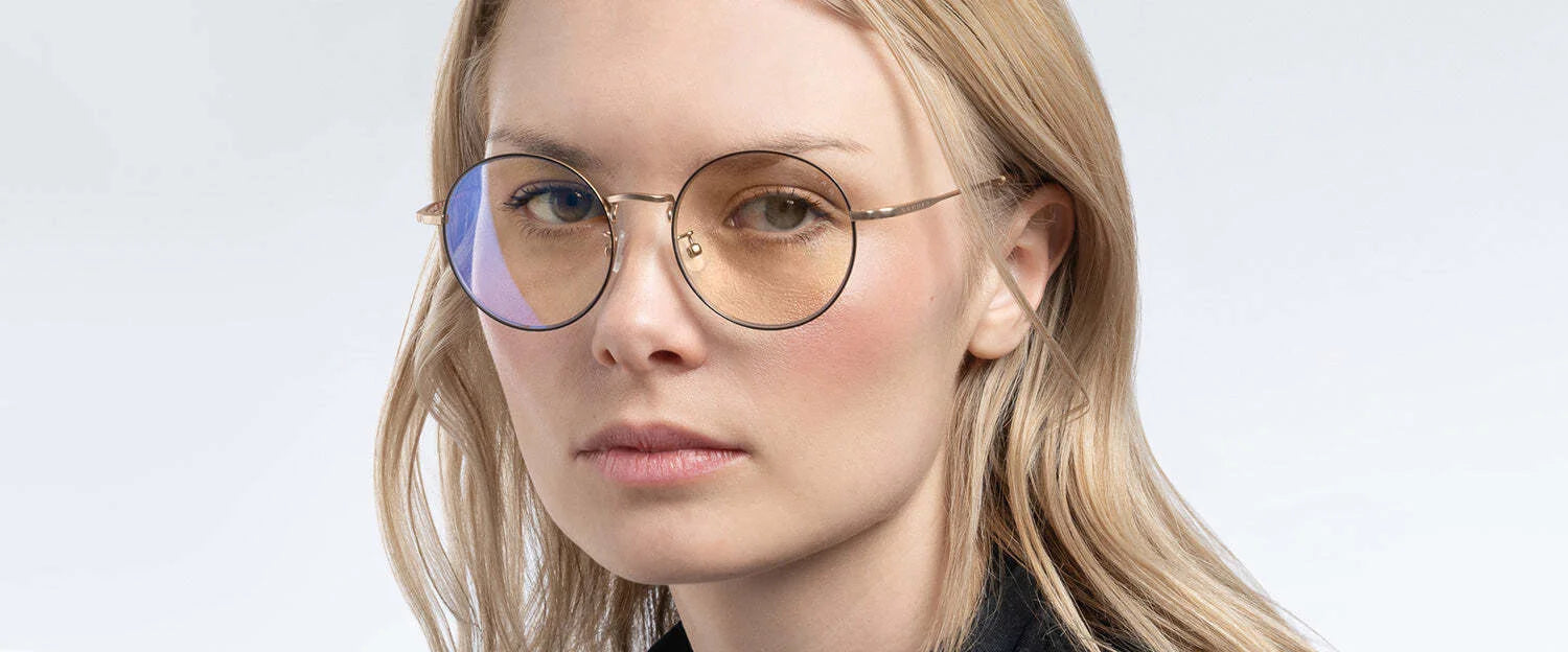 A person with blonde hair and round Gunnar Ellipse Computer Glasses (Size 51), featuring a stainless-steel frame, looks slightly to the side against a plain background. A person with blonde hair and round Gunnar Ellipse Computer Glasses (Size 51), featuring a stainless-steel frame, looks slightly to the side against a plain background.