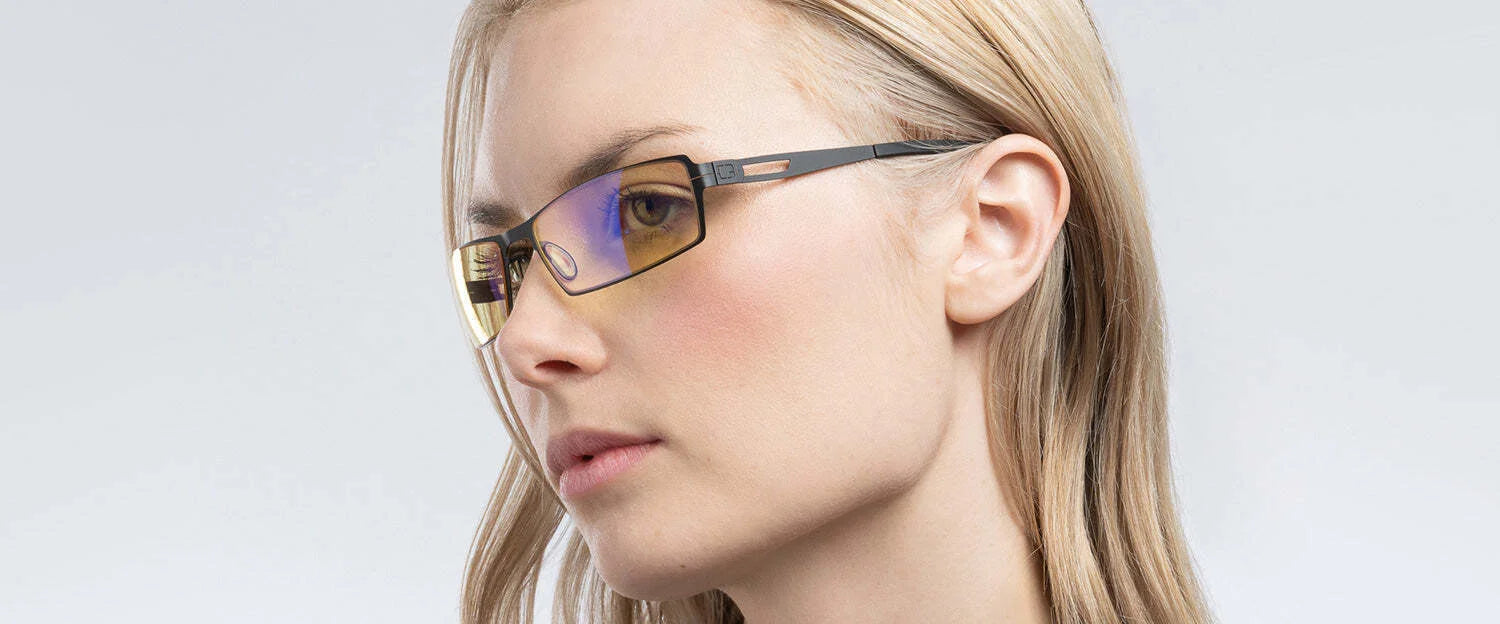 A blonde person wearing Gunnar Sheadog Computer Glasses (Size 56) with yellow-tinted lenses gazes sideways, effortlessly blending style with blue light blocking technology. A blonde person wearing Gunnar Sheadog Computer Glasses (Size 56) with yellow-tinted lenses gazes sideways, effortlessly blending style with blue light blocking technology.
