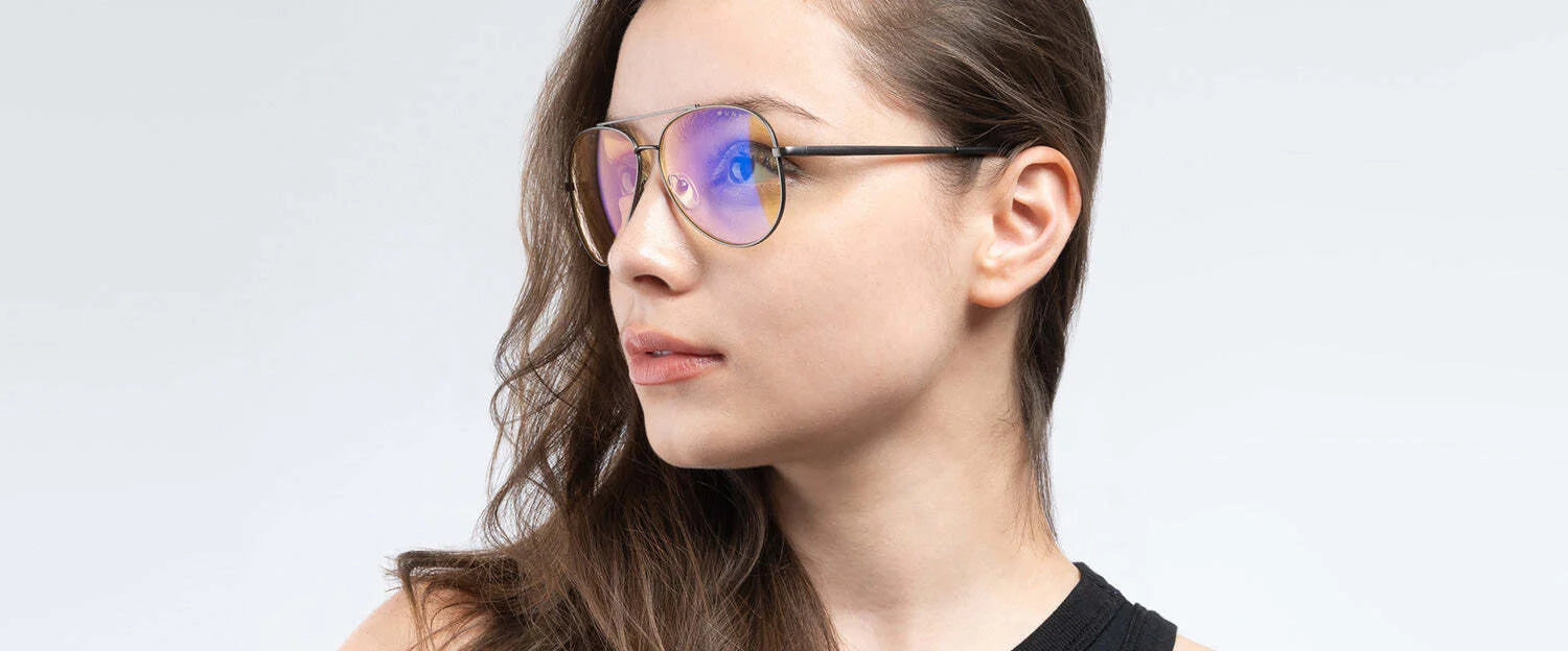 A person with long brown hair, wearing Gunnar Maverick Computer Glasses | Size 58, gazes to the side while donning a black sleeveless top. A person with long brown hair, wearing Gunnar Maverick Computer Glasses | Size 58, gazes to the side while donning a black sleeveless top.