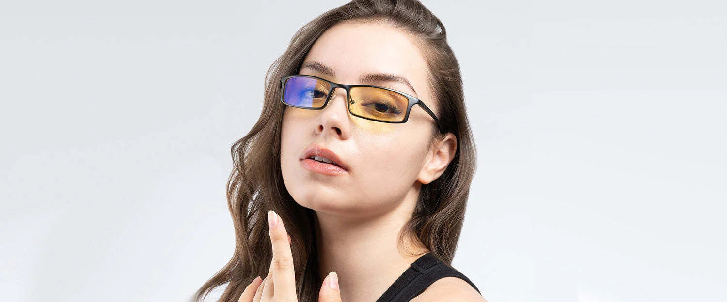 A PHENOM in optical tech, this person with wavy hair wears Gunnar Phenom Computer Glasses (size 55) featuring yellow lenses that filter blue light, set against a plain background. A PHENOM in optical tech, this person with wavy hair wears Gunnar Phenom Computer Glasses (size 55) featuring yellow lenses that filter blue light, set against a plain background.