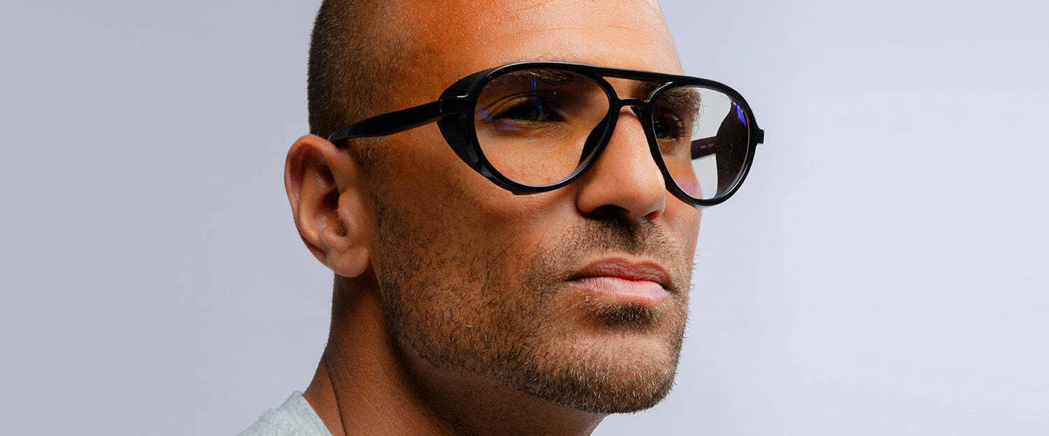 A man with short hair and stubble sports Gunnar Tallac Computer Glasses, featuring large black-rimmed frames made from premium acetate, against a plain background. A man with short hair and stubble sports Gunnar Tallac Computer Glasses, featuring large black-rimmed frames made from premium acetate, against a plain background.