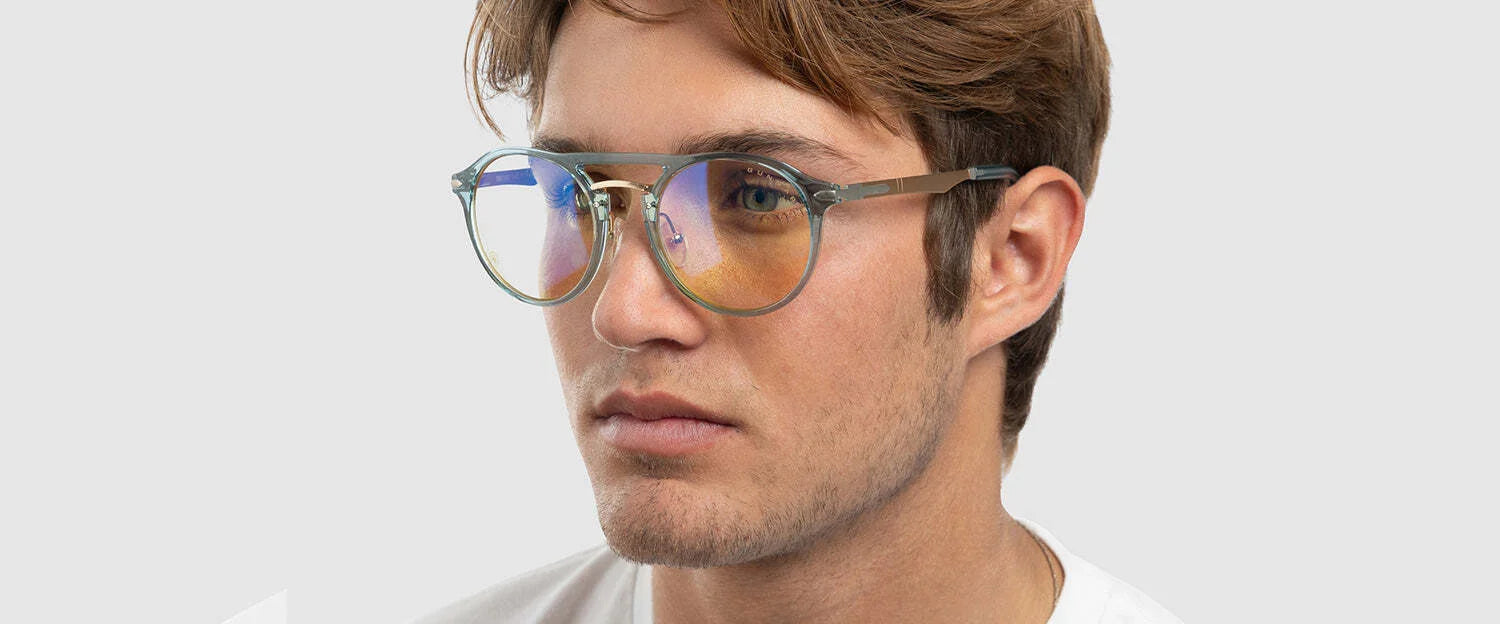 A person in a white shirt with a neutral expression dons the Gunnar World of Warcraft Alliance Edition Computer Glasses, known for their blue light-blocking capabilities. A person in a white shirt with a neutral expression dons the Gunnar World of Warcraft Alliance Edition Computer Glasses, known for their blue light-blocking capabilities.