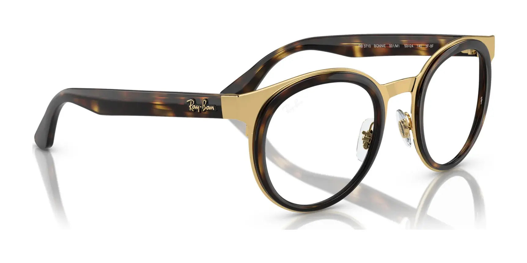 The Ray-Ban BONNIE RB3710 Eyeglasses, size 50, feature round tortoiseshell plastic rims with gold accents and clear lenses. They showcase a distinguished silhouette and boast the iconic Ray-Ban logo on the temple for a stylish and sophisticated look. The Ray-Ban BONNIE RB3710 Eyeglasses, size 50, feature round tortoiseshell plastic rims with gold accents and clear lenses. They showcase a distinguished silhouette and boast the iconic Ray-Ban logo on the temple for a stylish and sophisticated look.
