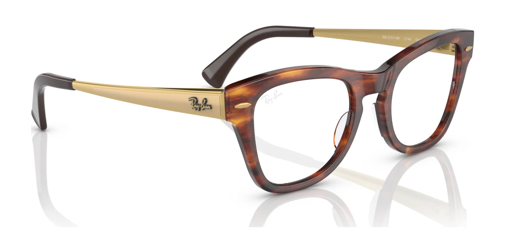 The Ray-Ban RX0707VM Eyeglasses in tortoiseshell and gold, featuring thick frames and sleek temples, reflected on a white surface, epitomize iconic design. The Ray-Ban RX0707VM Eyeglasses in tortoiseshell and gold, featuring thick frames and sleek temples, reflected on a white surface, epitomize iconic design.