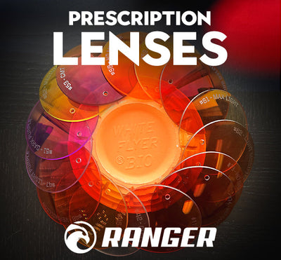A stack of colorful RE Ranger Spare Prescription Lenses surrounds a clay target, with "Prescription Lenses" and "RE Ranger" above.