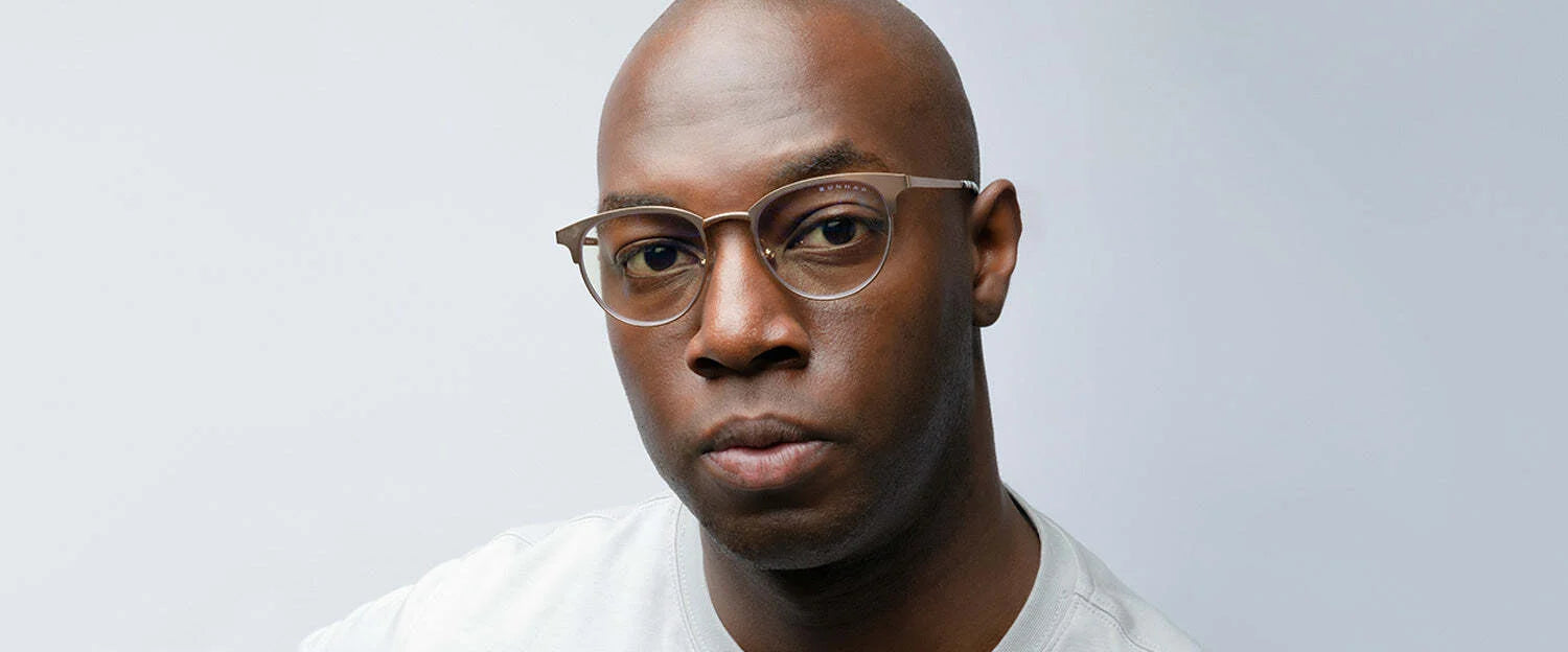 A man wearing Gunnar Apex Computer Glasses | Size 51, designed to combat digital eye strain, sports a neutral expression and a light gray shirt against a pale background.