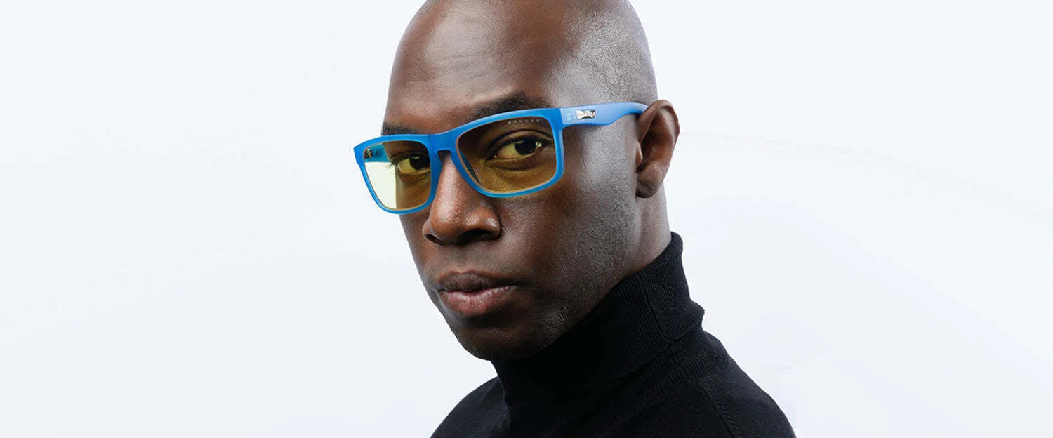 A man wears Gunnar Intercept Computer Glasses, size 58, featuring blue light protection and blue frames, paired with a black turtleneck against a plain white background.