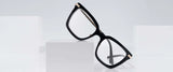 Gunnar Kaia Computer Glasses, Size 53, with black square frames and blue light blocking technology, are displayed on a white cube against a light gray background. These contemporary Gunnar glasses offer both fashion and functionality.