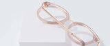 Gunnar Lahti Computer Glasses in rose-gold are elegantly displayed on white blocks, highlighting their chic side profile. Featuring GUNNAR lens technology, these designer glasses combine style with blue light protection for the modern individual.