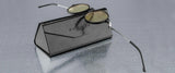 The Gunnar Loop Computer Glasses, with round lenses and advanced lens technology for better productivity, are placed on a black leather case atop a reflective surface.