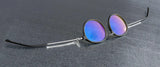 Gunnar Loop Computer Glasses, Size 51, featuring metallic frames and purple-tinted lenses, rest on a gray surface. Equipped with Gunnar lens technology to filter blue light, they enhance both style and productivity.