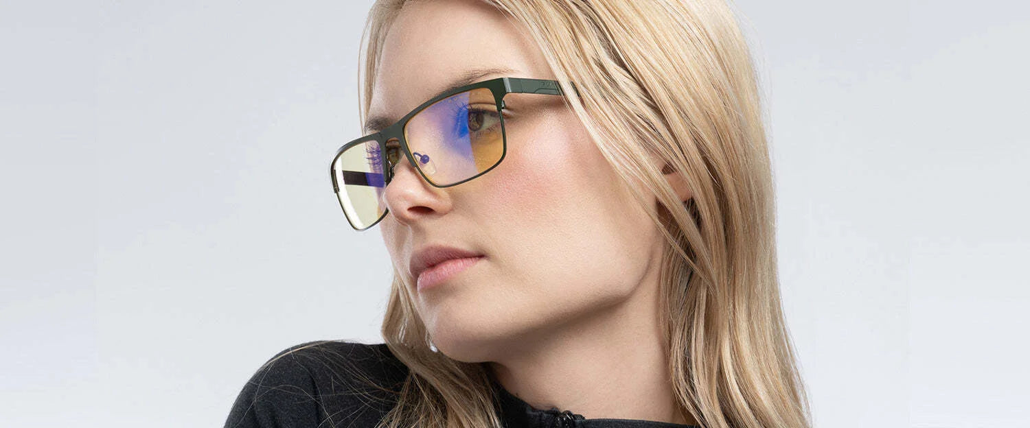 A person with long blonde hair wearing Gunnar Pendleton Computer Glasses | Size 57, featuring yellow-tinted, blue-light blocking lenses, gazes thoughtfully to the side against a light background.