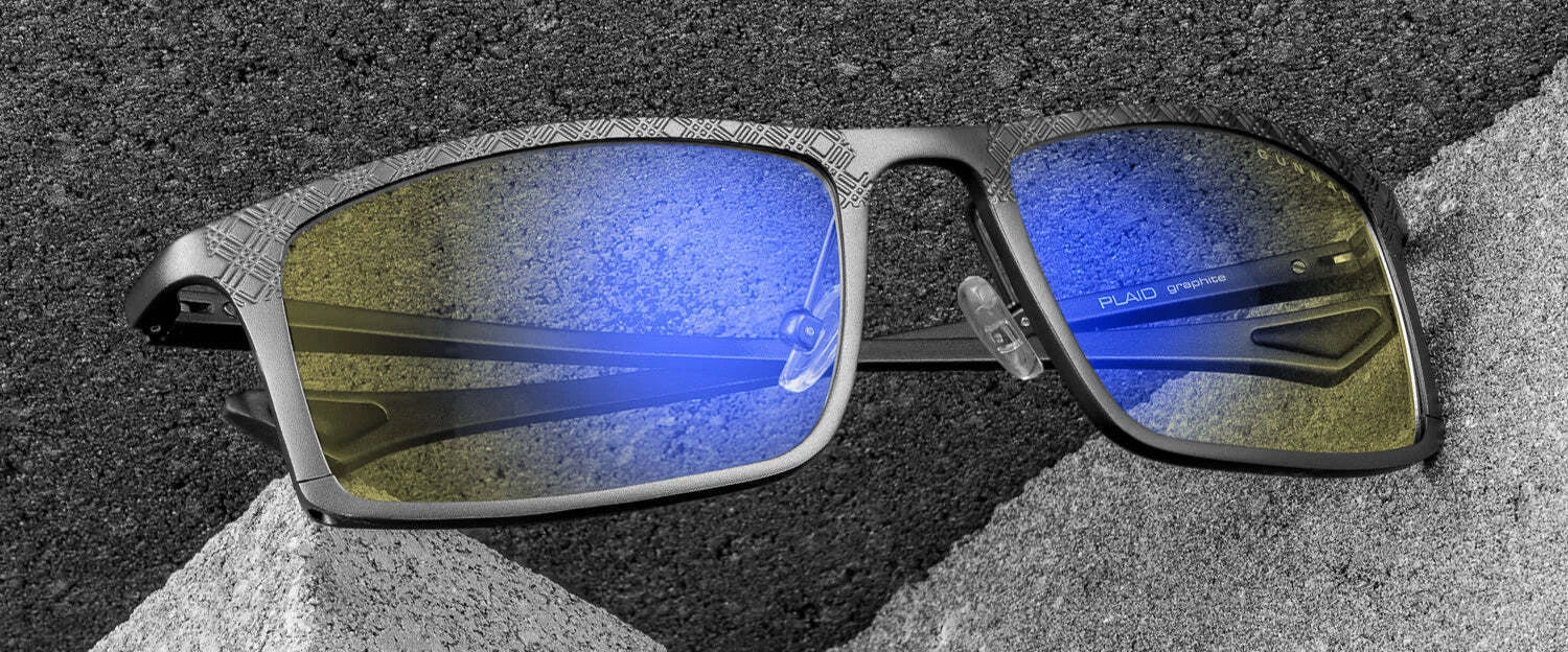 Elegant close-up of Gunnar Plaid Computer Glasses, showcasing sleek blue lenses made from a magnesium-aluminum alloy, displayed stylishly on concrete surfaces.