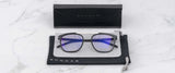 The Gunnar Pismo Computer Glasses | Size 50, by Gunnar, with blue light-filtering lenses, rest elegantly in a black case with a pouch on the marble surface.