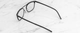 Gunnar Pismo Computer Glasses, in classic black with thin frames, rest elegantly on a white marble surface, providing stylish comfort and potential blue light protection.