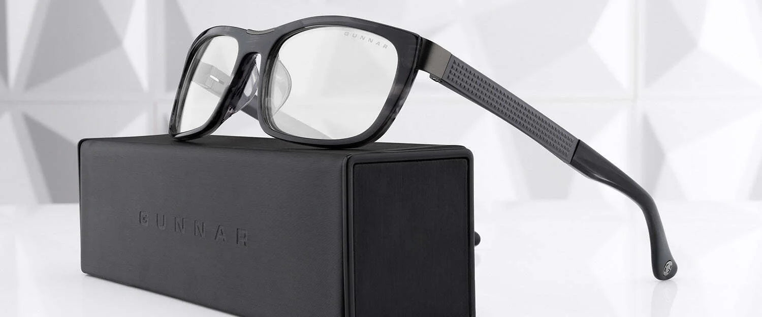 Gunnar Tahoe Computer Glasses, with black rims and a blue light blocking feature, rest elegantly on a black box against a geometric white background.