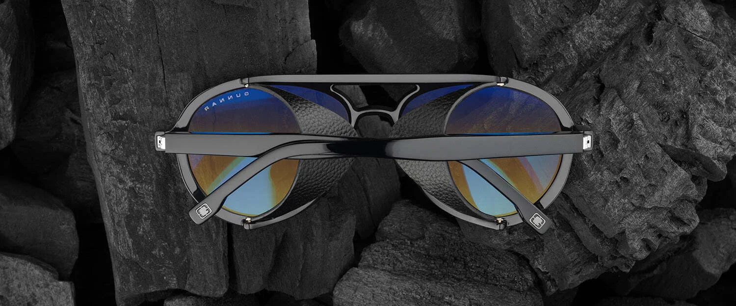 The Gunnar Tallac Computer Glasses in size 57, featuring a premium acetate frame and blue reflective lenses, combine rugged durability with sleek elegance on a dark textured background.