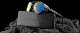 Gunnar Tallac Computer Glasses in size 57 showcase reflective lenses elegantly resting on a black case amid dark rocks and a black backdrop. With a premium acetate frame, these Gunnar glasses deliver durability and style for adventure enthusiasts.