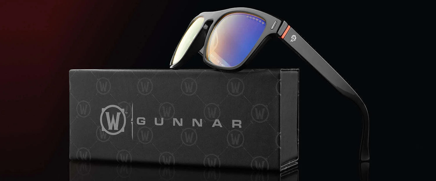 The Gunnar World of Warcraft Horde Edition Computer Glasses in black, size 51, with GUNNAR patented lens technology, are seen elegantly resting on a matching branded case against a dark background.