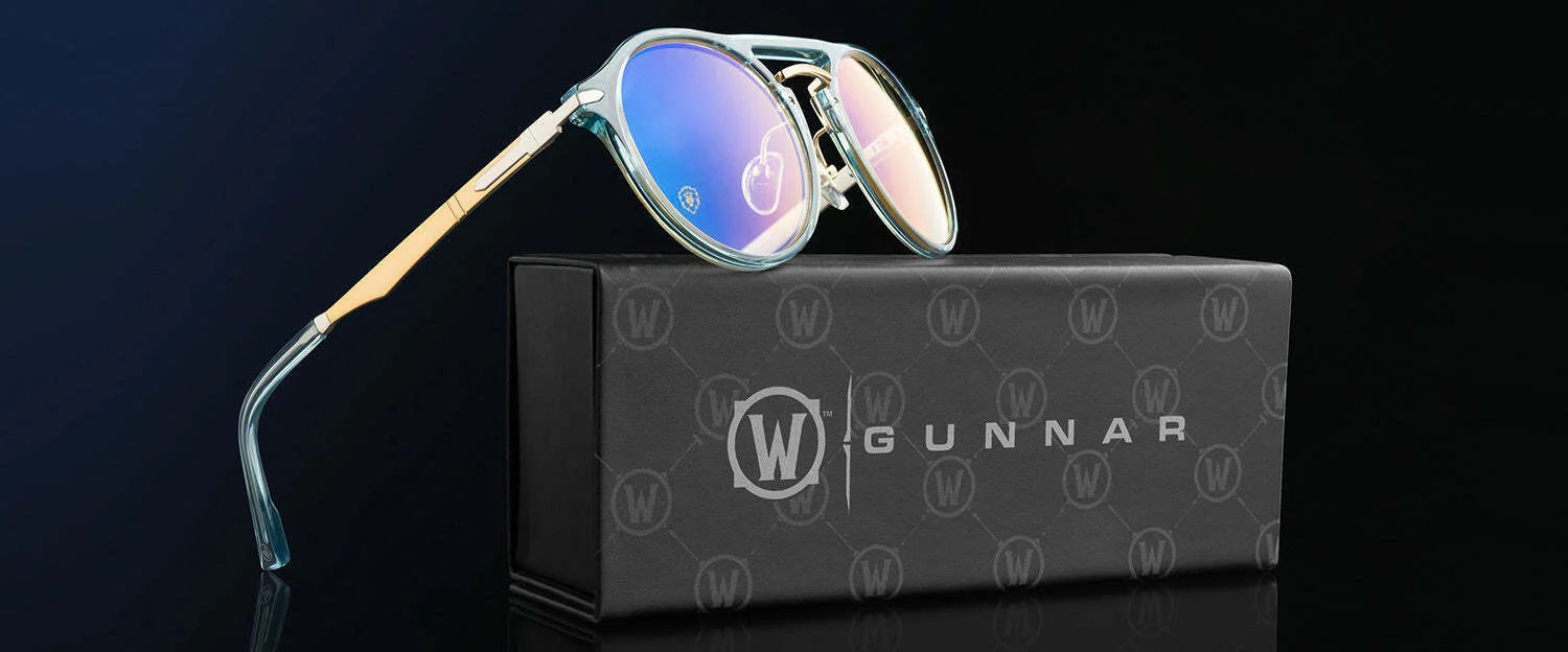 Gunnar World of Warcraft Alliance Edition Computer Glasses with blue-tinted, blue light blocking lenses are showcased on a sleek black Gunnar box against a dark background.