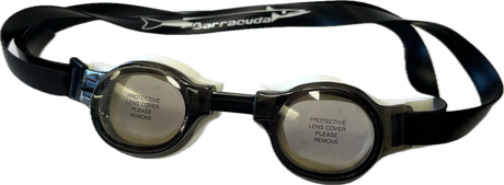 The Barracuda Medalist Swimming Goggles in smoke, ideal for both training and competition, come with protective lens covers labeled "PROTECTIVE LENS COVER PLEASE REMOVE," making them perfect for younger swimmers.