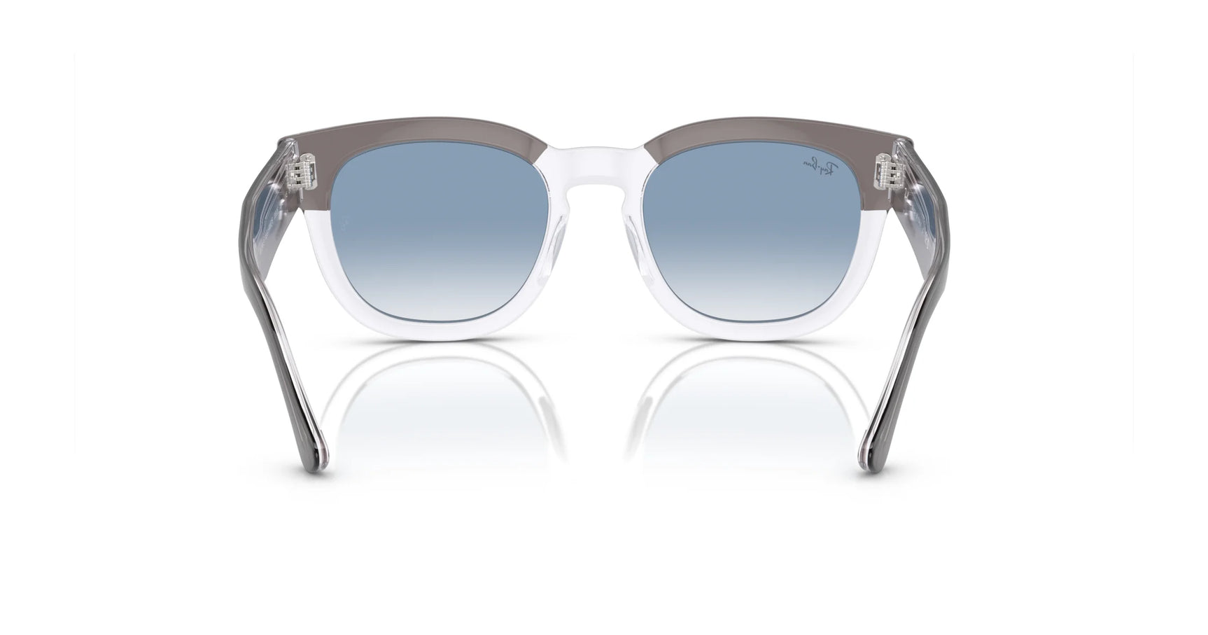 The Ray-Ban MEGA HAWKEYE RB0298SF Sunglasses, featuring a blue gradient lens, translucent frames, and a sleek square-shaped design in size 53 are displayed on a reflective surface.