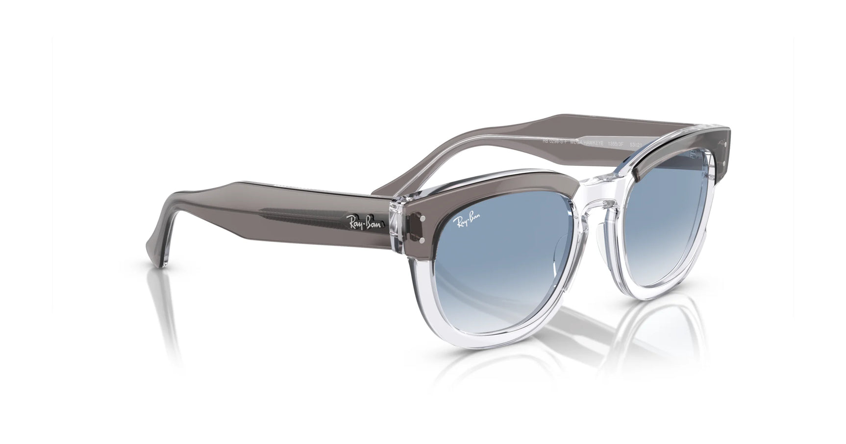 Ray-Ban MEGA HAWKEYE RB0298SF Sunglasses, with clear and gray square acetate frames and gradient blue lenses,  size 53 are elegantly displayed on a reflective surface.