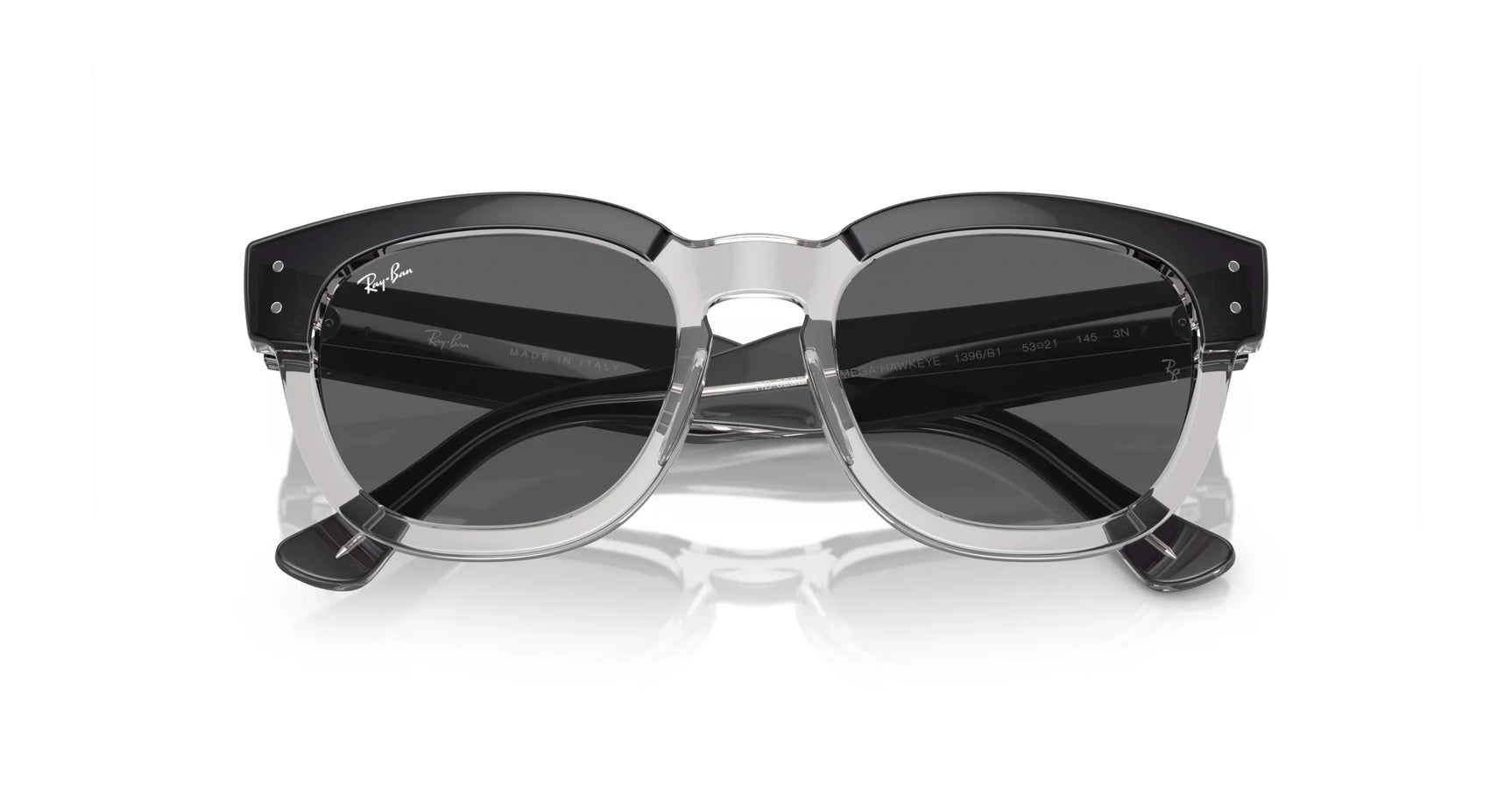 Ray-Ban MEGA HAWKEYE RB0298SF Sunglasses with black and transparent square acetate frames rest stylishly on a reflective surface, their dark lenses radiating timeless elegance.