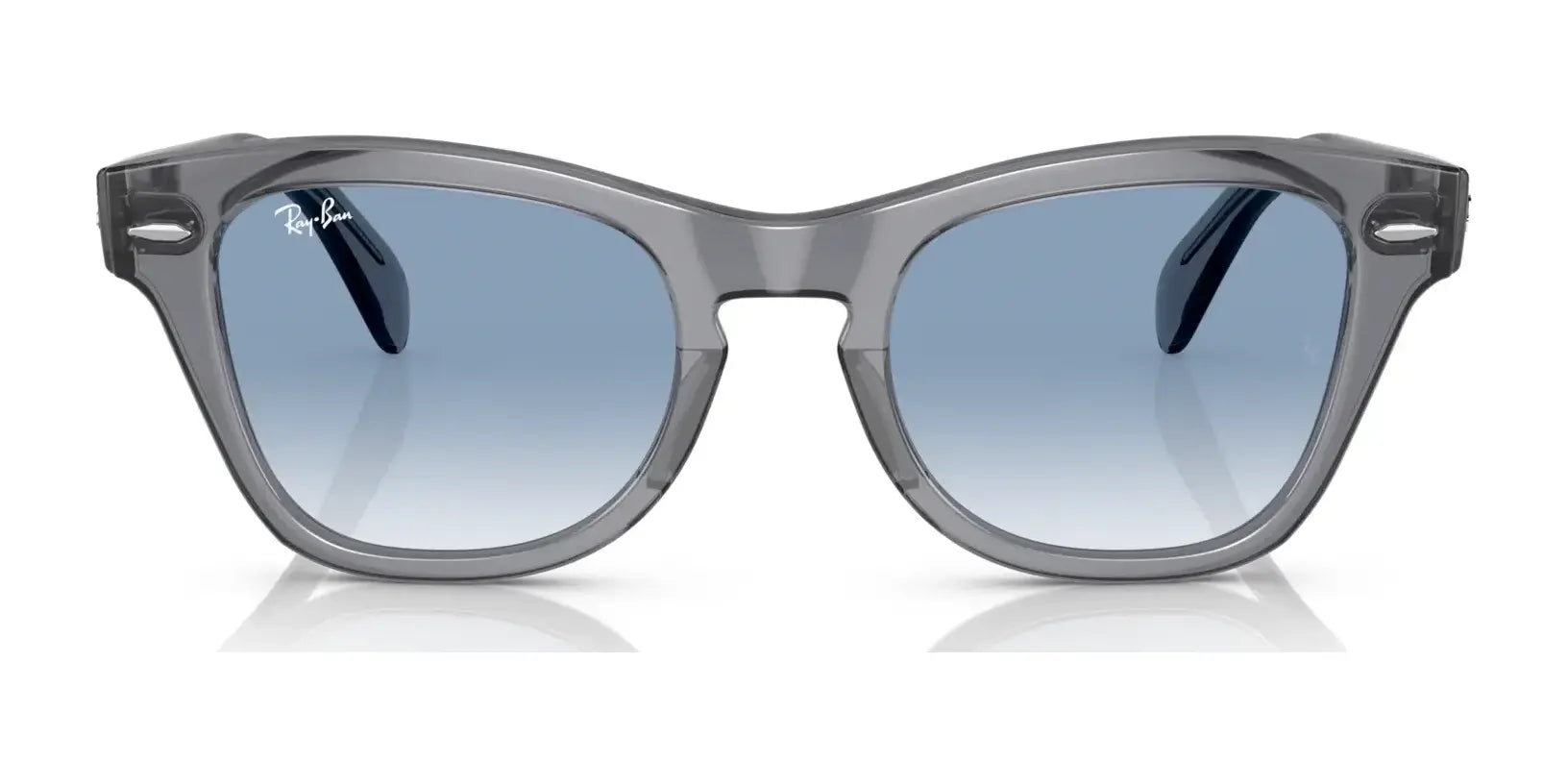 The Ray-Ban RB0707S Sunglasses feature a sleek gray acetate frame and blue-tinted lenses with a modern square shape, set against a white background.