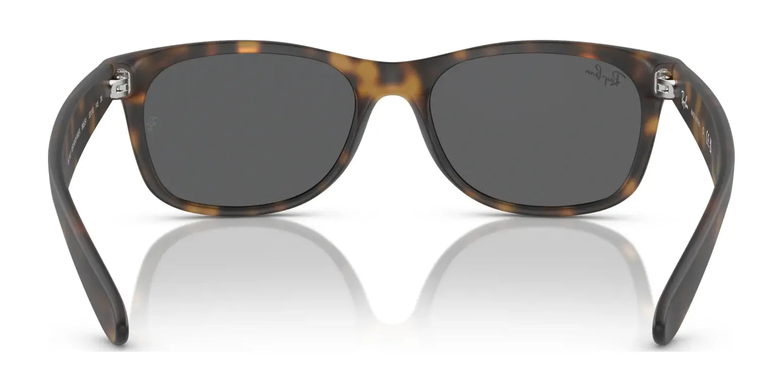 Ray-Ban NEW WAYFARER RB2132 sunglasses, tortoise shell with dark lenses, stylishly rest on a reflective surface, offering 100% UV protection.