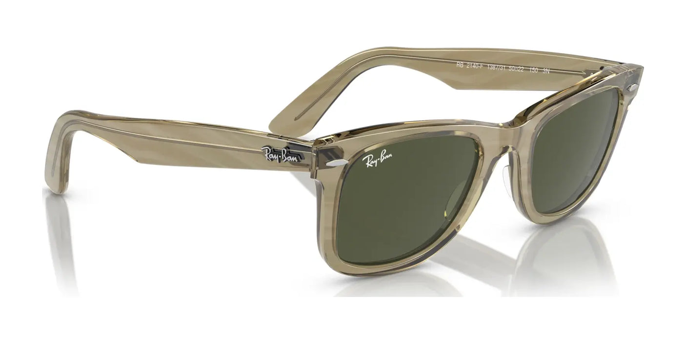 The Ray-Ban WAYFARER RB2140F Sunglasses, featuring clear frames and dark lenses with the Ray-Ban logo on the temple, are displayed elegantly on a reflective surface, offering both fashion and UV protection.