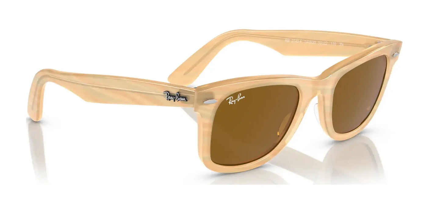 The Ray-Ban WAYFARER RB2140F Sunglasses boast a chic design with beige frames and brown lenses, along with the iconic logo on the arms, delivering both style and UV protection.