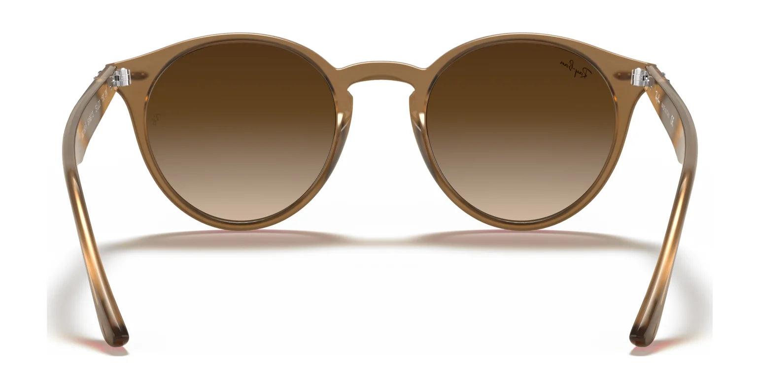 Ray-Ban RB2180F Sunglasses, with transparent brown frames and brown gradient lenses, provide essential UV protection and a stylish oval shape that complements any face. Size 49.