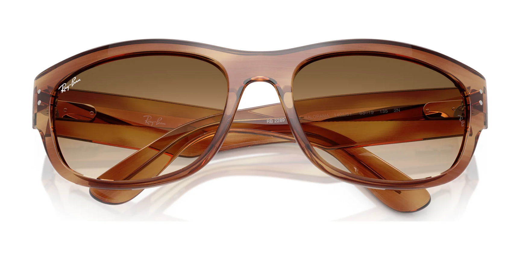 Ray-Ban MEGA BALORAMA RB2289 sunglasses exude classic style and sporty design with their brown oversized frames and tinted lenses, showcased with arms confidently crossed on a white backdrop.