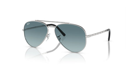 The Ray-Ban NEW AVIATOR RB3625 sunglasses, featuring silver frames and green-tinted lenses, stylishly rest on a reflective surface while offering optimal UV protection.