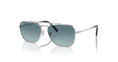 Ray-Ban NEW CARAVAN RB3636 sunglasses with silver frames and blue-tinted lenses, reflecting light on a white surface.