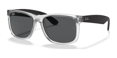 The Ray-Ban JUSTIN RB4165 sunglasses feature a square shape with clear frames, black arms, and dark lenses on a white background. They offer stylish UV protection to keep your eyes safe while staying fashionable in the transparent №651287 color.