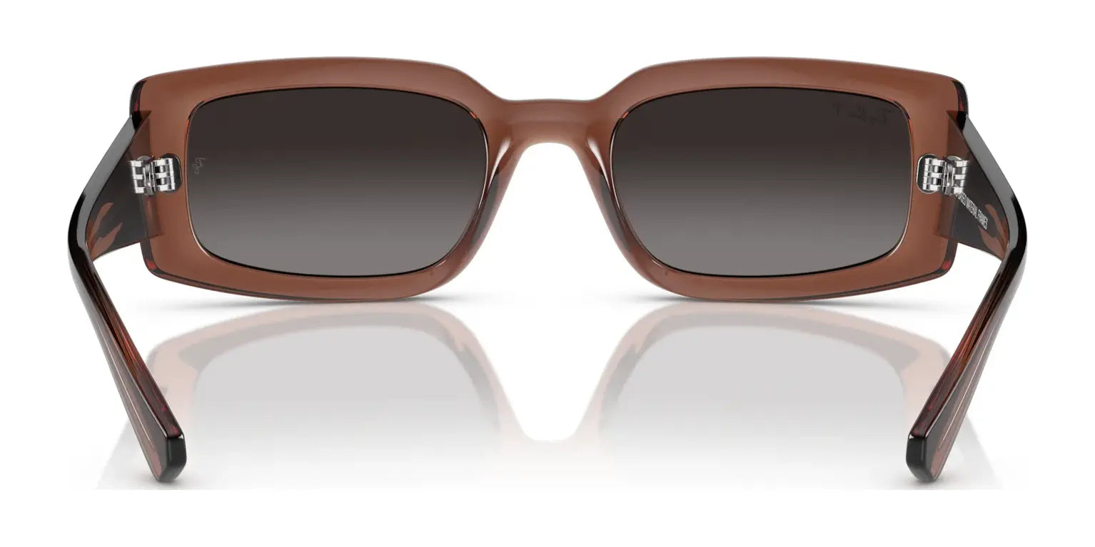 The Ray-Ban KILIANE RB4395 Sunglasses in size 54 feature a chic brown rectangular frame made from bio-based acetate, equipped with dark UV-protective lenses and wide temples, elegantly showcased against a white background.