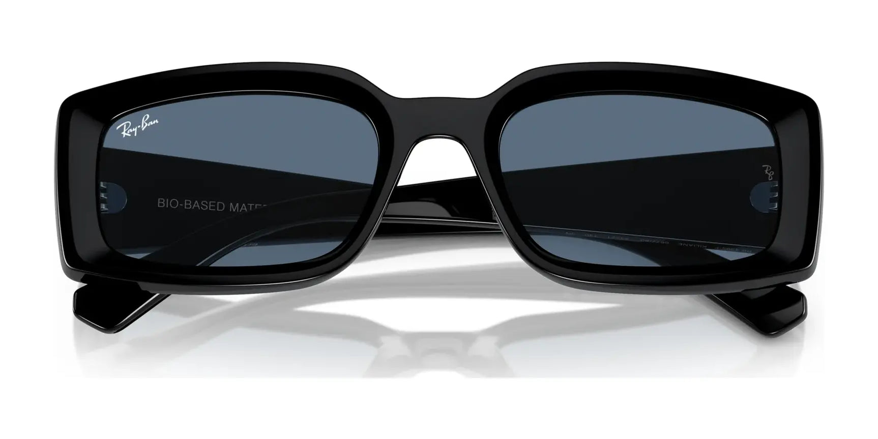 The Ray-Ban KILIANE RB4395F Sunglasses, size 54, with black rectangular frames and dark lenses, sit elegantly on a reflective surface, exuding a luxurious style.