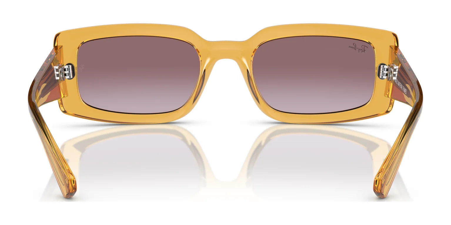 These Ray-Ban KILIANE RB4395F Sunglasses in size 54 boast amber frames and brown-tinted lenses, showcased on a reflective surface to highlight their sophisticated style and premium materials.