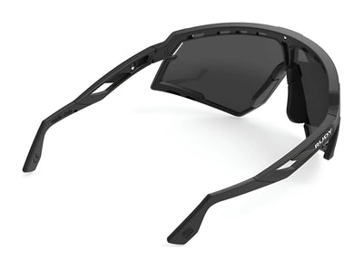 Rudy Project Defender Sunglasses | Size 141 by Rudy Project shown from an angled rear view, featuring thick black frames and dark lenses. Interchangeable lenses provide customizable vision for various light conditions.