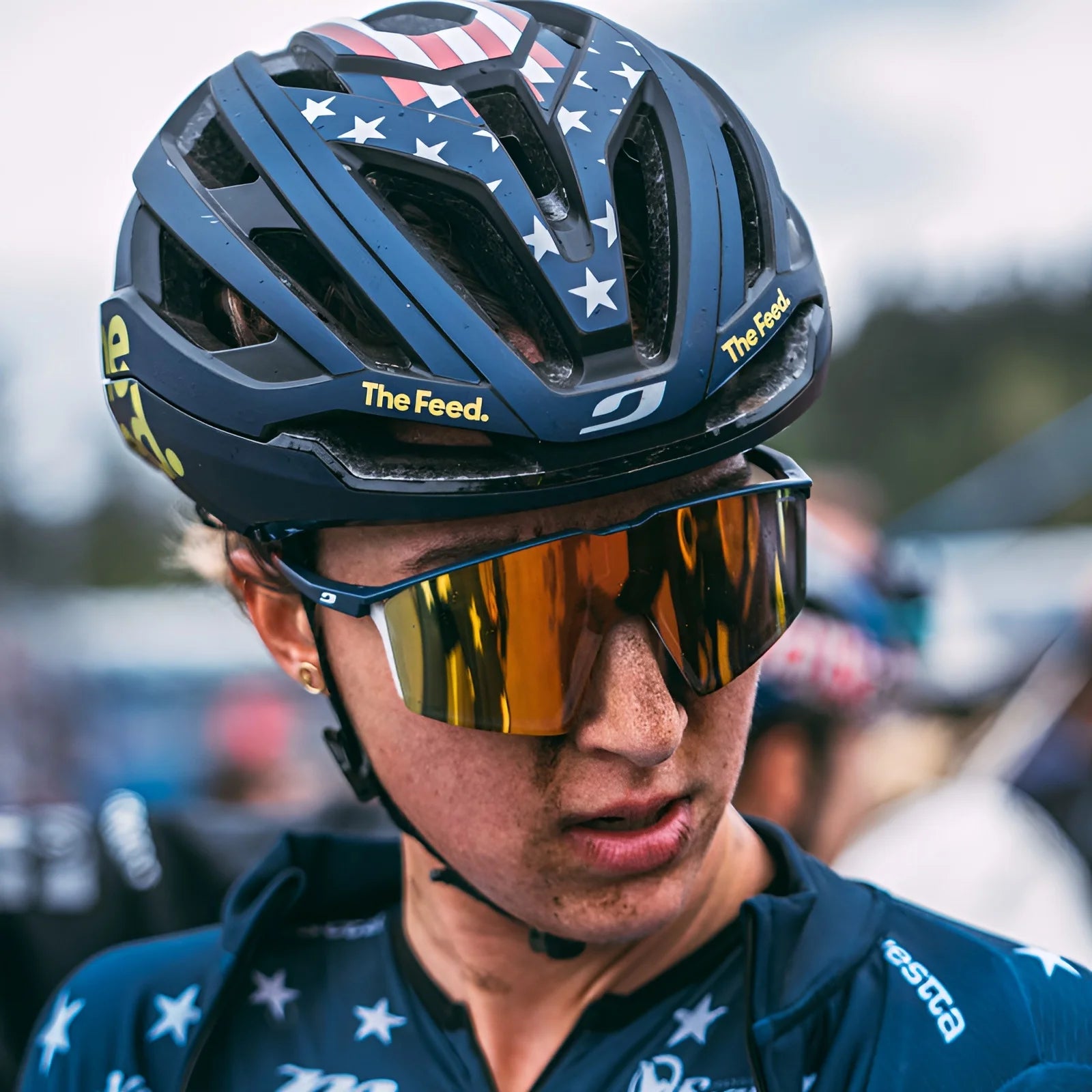 The cyclist, wearing a star-patterned helmet, sported Julbo Edge Sunglasses by Julbo with reflective lenses and anti-fog coating, exuding focus and determination during the race.