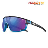 The Julbo Rush Sunglasses by Julbo feature blue-tinted photochromic lenses, sleek black-and-blue frames with REACTIV Technology branding, and adjustable temples for a perfect fit.