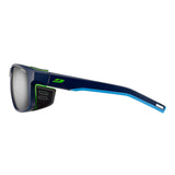 The Julbo Shield Sunglasses, Size 59, by Julbo are sporty blue with green accents, featuring protective side shields, a Grip Nose for secure fit, and Air Flow ventilation for cooling comfort.
